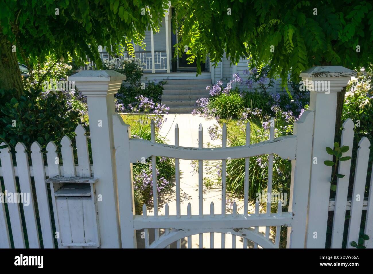 Gate and path leading to front door through old-world garden. Stock Photo