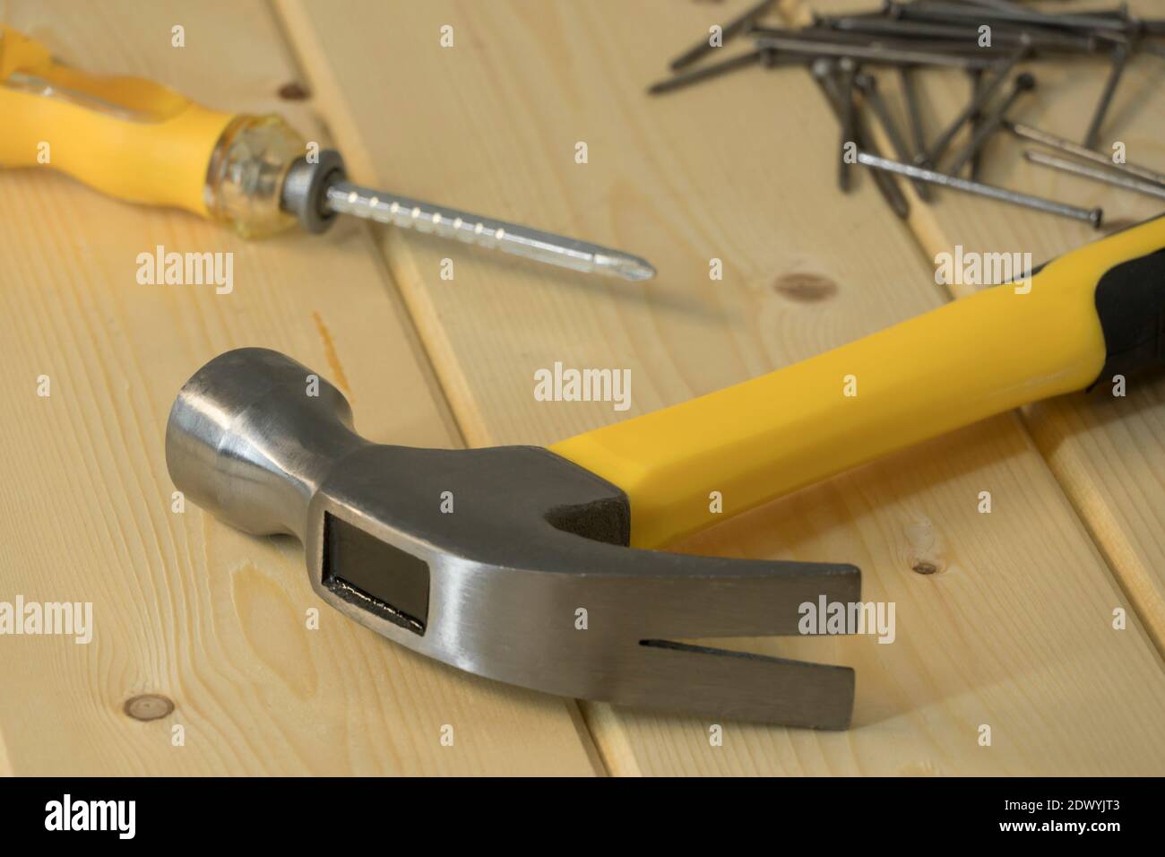 Assorted work tools on wood. Hand tools on a wooden background, hammer with nails and screwdriver. Home renovation, construction. Hand tools and equip Stock Photo
