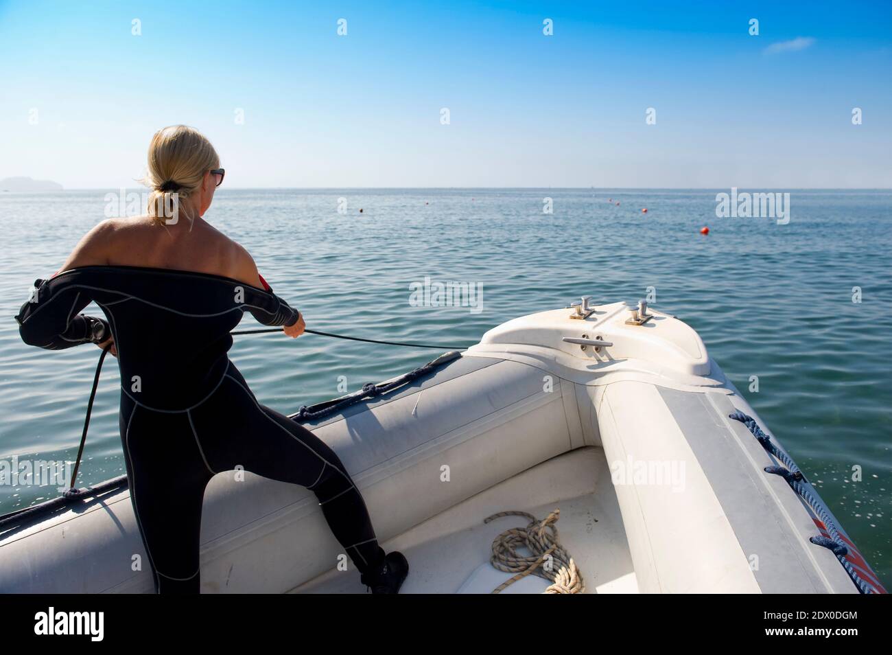 Scuba diver working on a inflatable boat. Baia (Baiae), Campi Flegrei (Phlegraean Fields), Naples, Campania, Italy Stock Photo