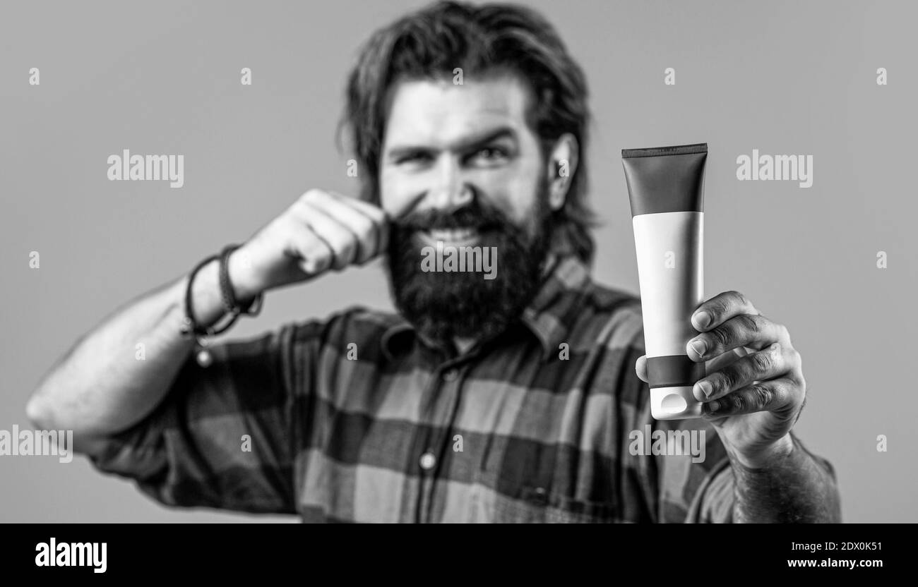 Man holds black bottle of shampoo or shower gel. Shampoo conditioner for men. Expert care for