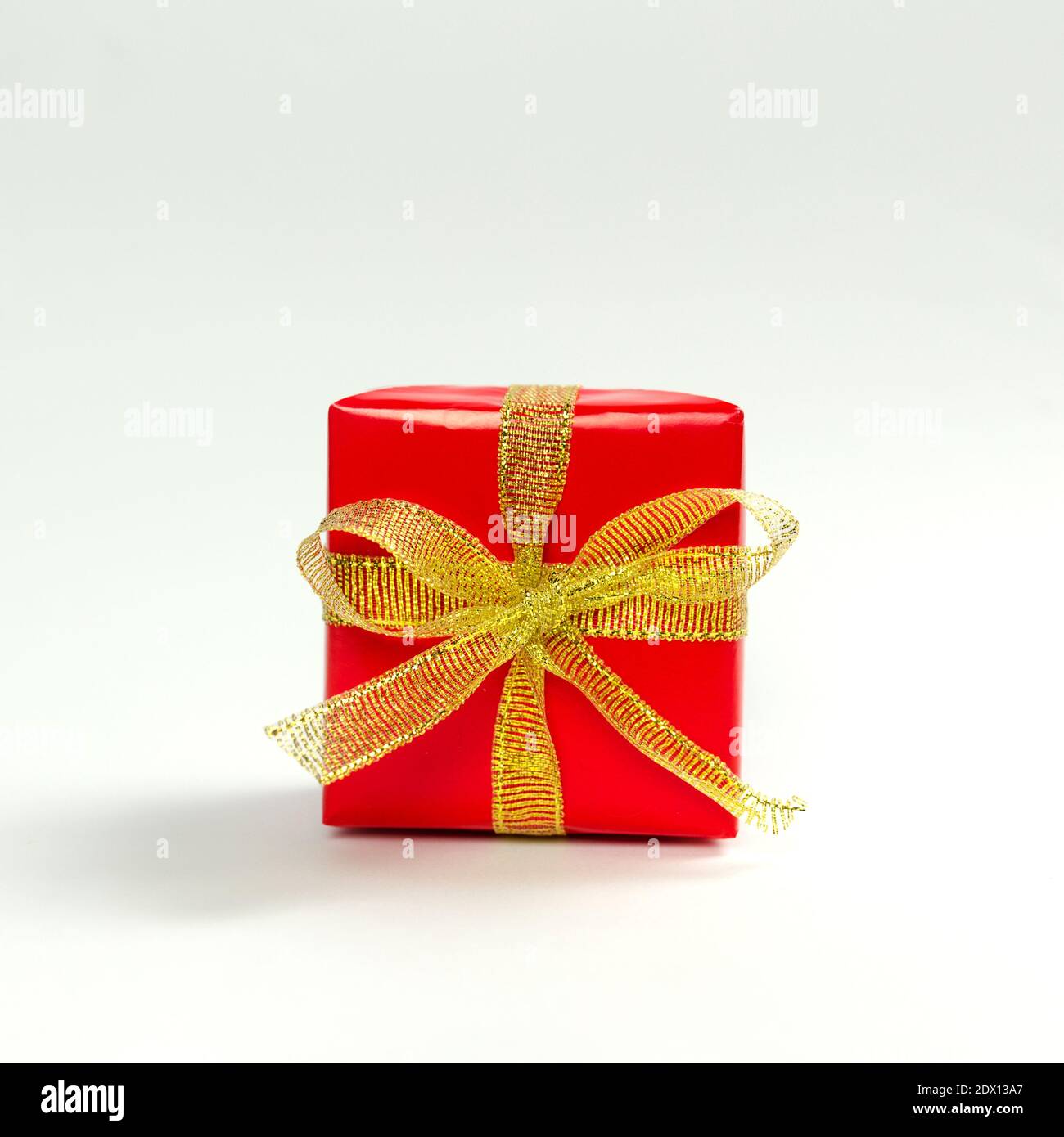 Red gift box with golden ribbon on white background Stock Photo - Alamy