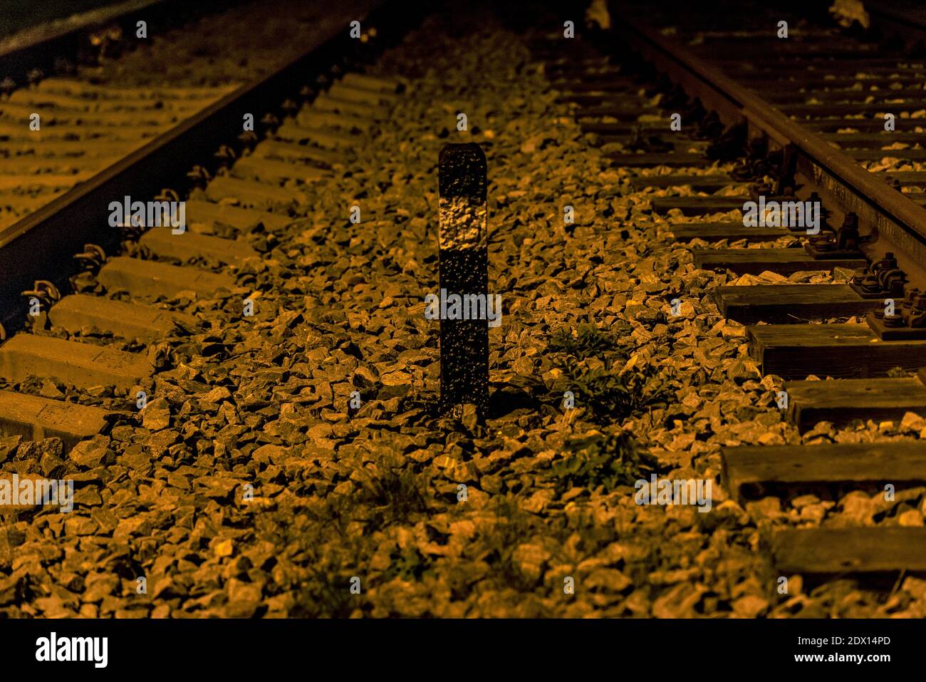 two railway tracks and a railway pole black with a white stripe and a ground glass crushed stone Stock Photo