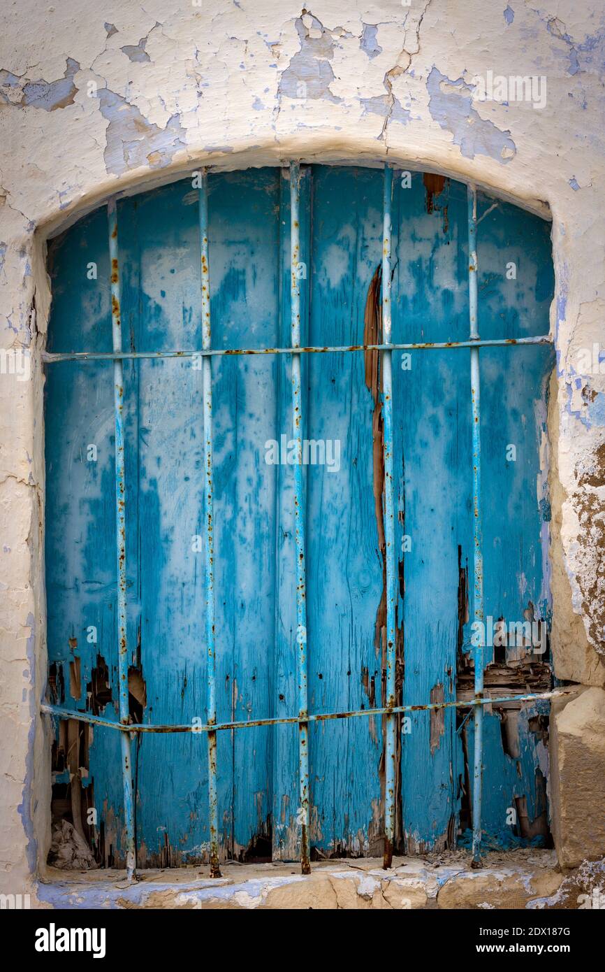 Rusty old blue window, clearly weathered by the passing of time, but still beautiful in its own way. Stock Photo