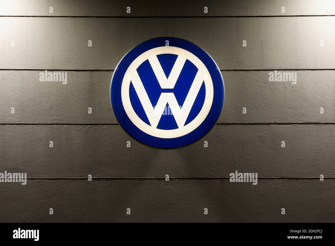 Lugano, Ticino, Switzerland - 3rd December 2020 : Luminous VW logo sign of Volkswagen AG haning on a dealership store in Lugano. VW is one of the worl Stock Photo