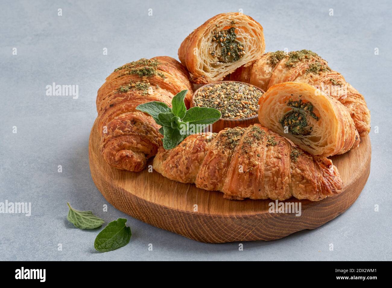 Croissants with zaatar on wooden board. Closeup Stock Photo