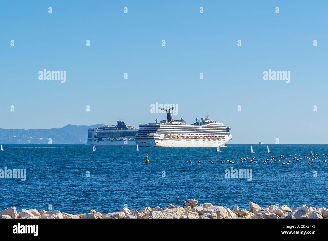 Naples, Italy, October 2020: Cruise ships in the bay of Naples sailing towards the mediterranean sea, Capri Island on background. Stock Photo
