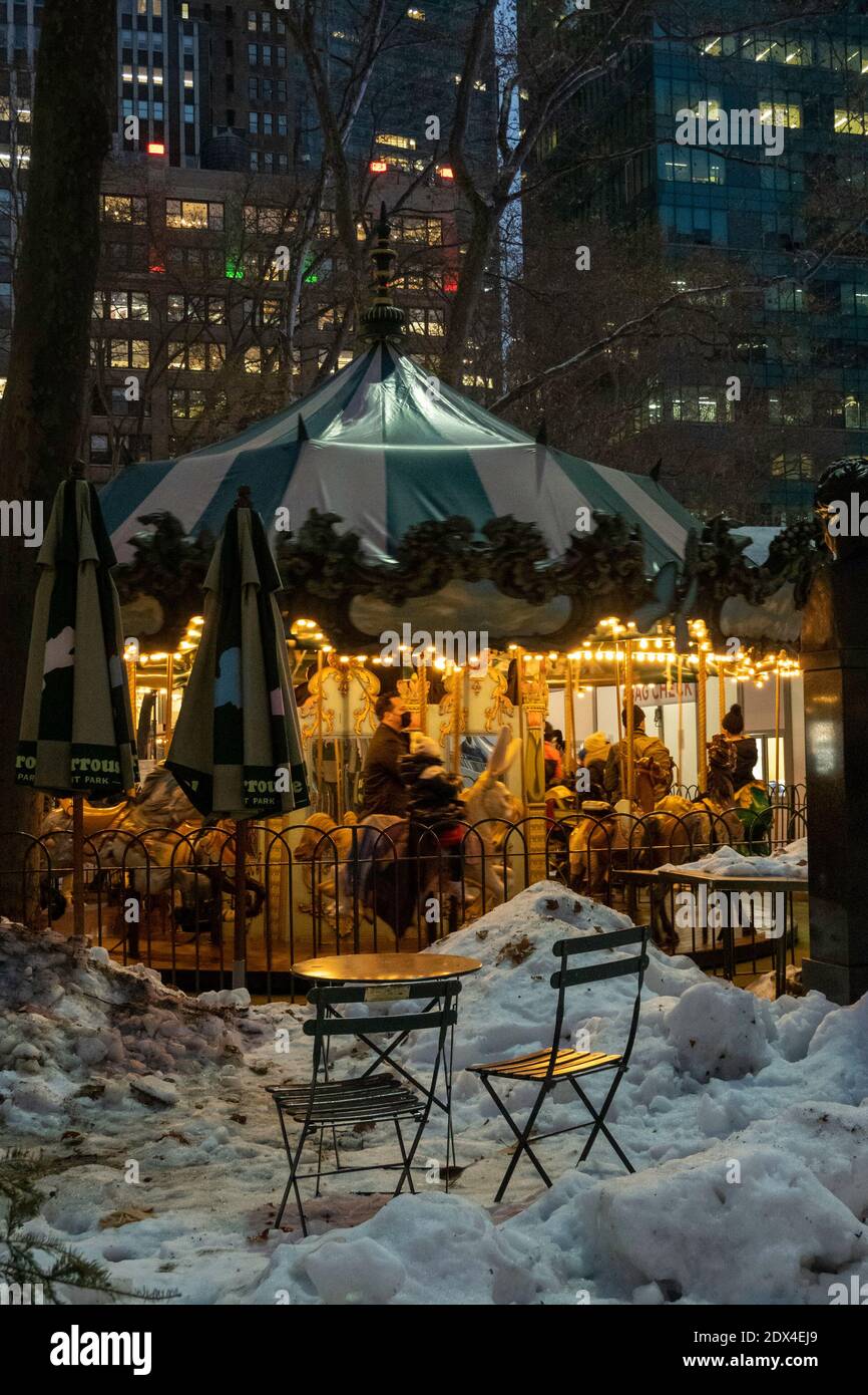 Le Carrousel in Bryant Park is brightly lit on a snowy evening, New York City, USA Stock Photo