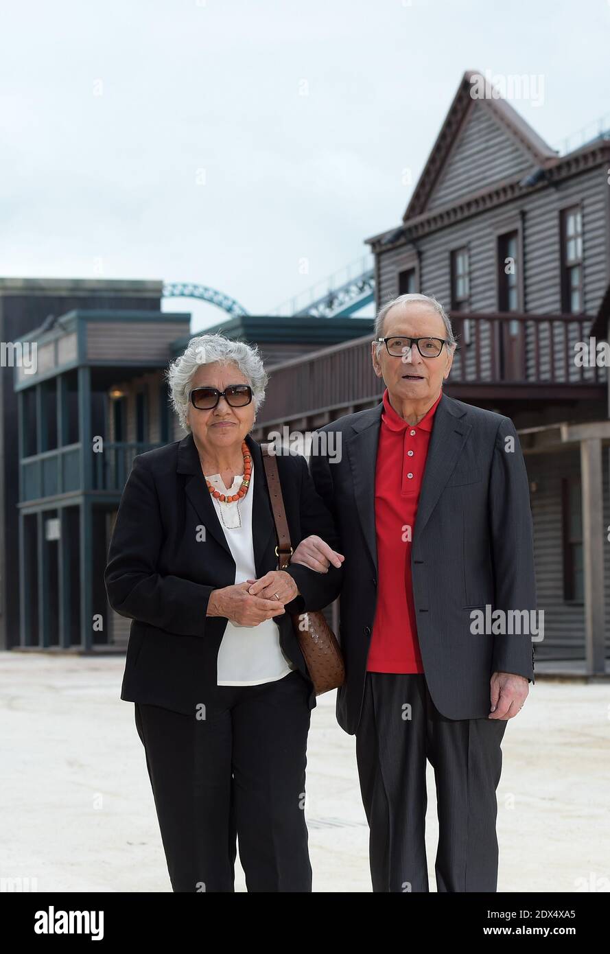Italian composer and Oscar-winning Ennio Morricone and his wife Maria Tavia visit 'Cinecitta World', the new italian movie theme park unveiled in Rome, Italy on July 10, 2014. The ambient music of the western set of the park is by Ennio Morricone, winner of the Honorary Academy Award for career achievement in 2007 and to whom the theme park's Westerns section is dedicated. The look of Cinecitta World is a mix of sword and sandals epics, Fellinesque and Bollywood elements, including gigantic elephants, science fiction, spaghetti westerns and many other themes concocted by Dante Ferretti from th Stock Photo