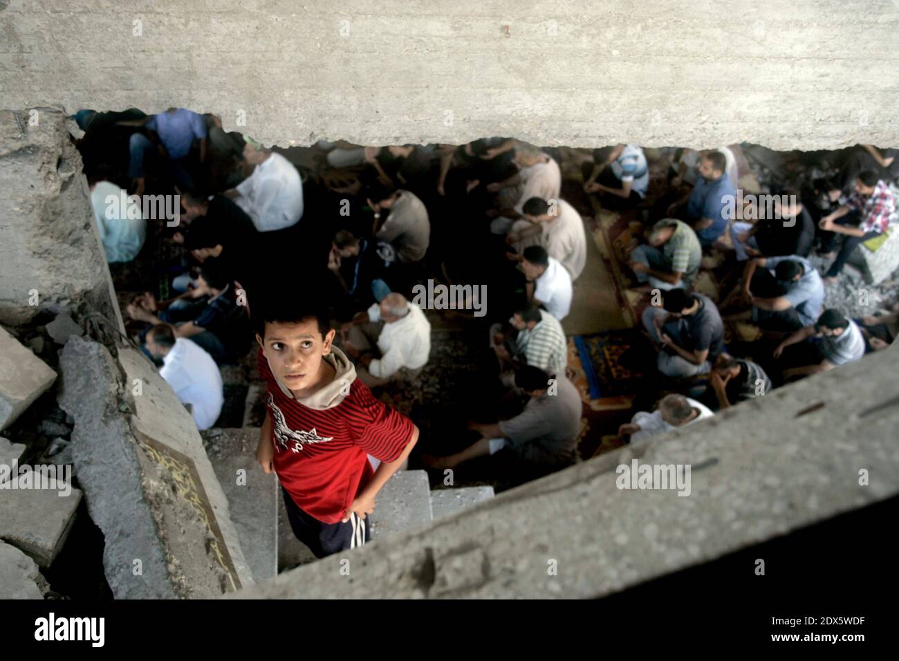 Palestinians attend Friday prayers inside a mosque which witnesses said was badly damaged by an Israel air strike during the offensive, on the second day of a five-day ceasefire in Gaza City August 15, 2014. Two successive truces since Monday, expected to last through August 19, have largely quieted the guns, after 1,945 Palestinians, most of them civilians, 64 Israeli soldiers and three civilians in Israel were killed. Photo by Abedllah Jadllah/ABACAPRESS.COM Stock Photo