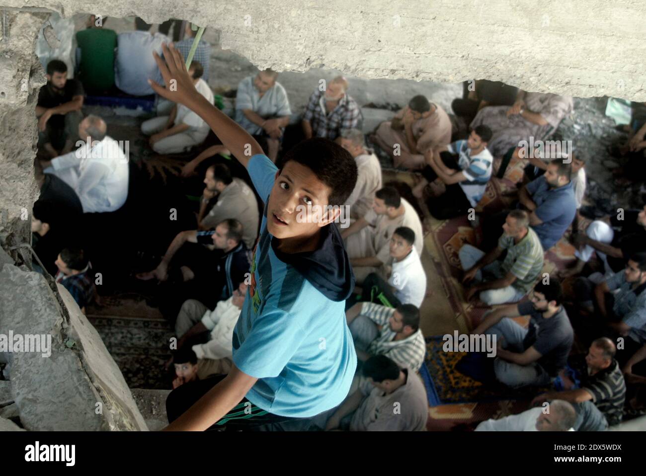 Palestinians attend Friday prayers inside a mosque which witnesses said was badly damaged by an Israel air strike during the offensive, on the second day of a five-day ceasefire in Gaza City August 15, 2014. Two successive truces since Monday, expected to last through August 19, have largely quieted the guns, after 1,945 Palestinians, most of them civilians, 64 Israeli soldiers and three civilians in Israel were killed. Photo by Abedllah Jadllah/ABACAPRESS.COM Stock Photo