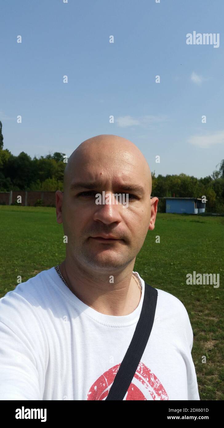 Portrait Of Completely Bald Man On Land Against Sky Stock Photo
