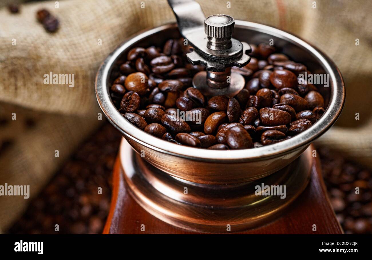 Vintage old coffee grinder with coffee beans in bag. Stock Photo