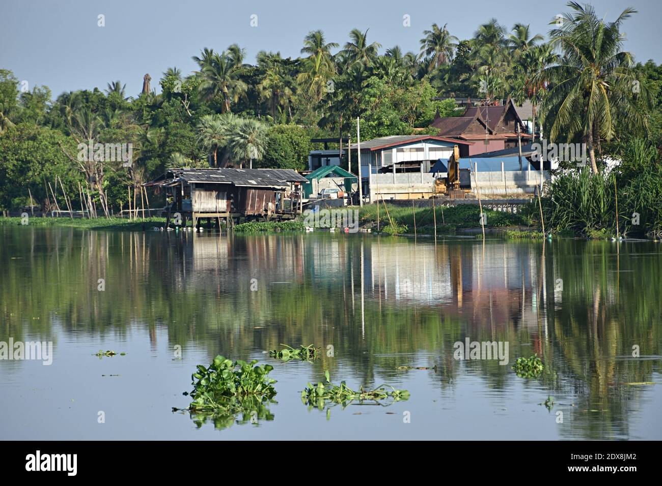 Thai houses in the countryside with its reflections on Nakhon Chai Si river, Nakhonchaisri, Thailand. Stock Photo