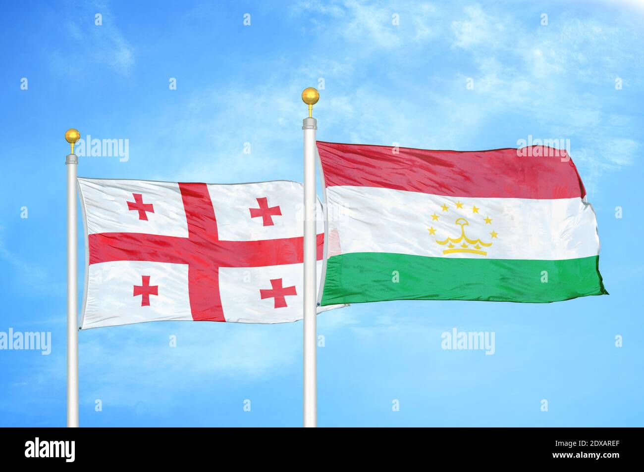 Georgia and Tajikistan two flags on flagpoles and blue sky Stock Photo