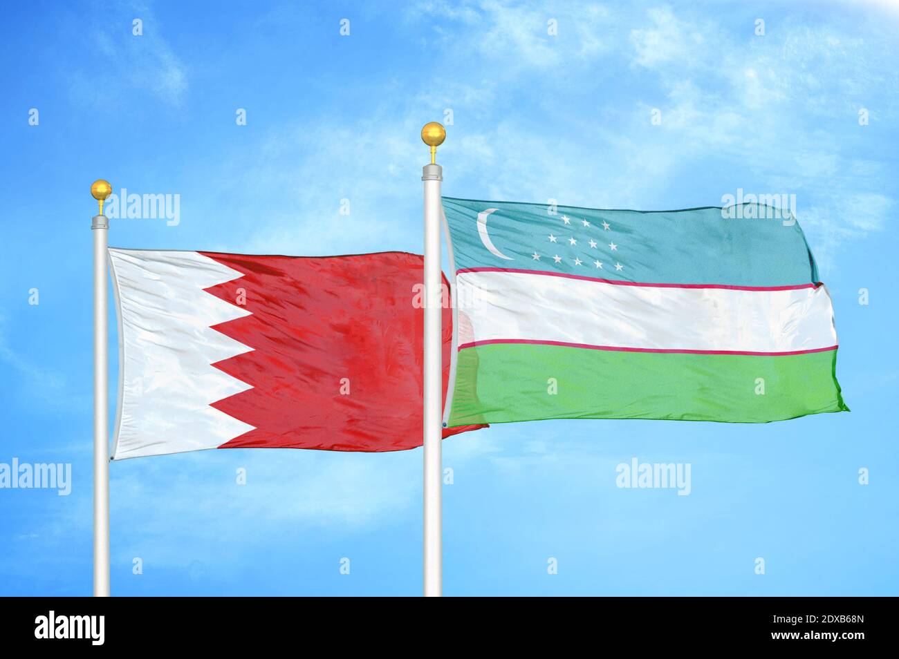 Bahrain and Uzbekistan two flags on flagpoles and blue sky Stock Photo