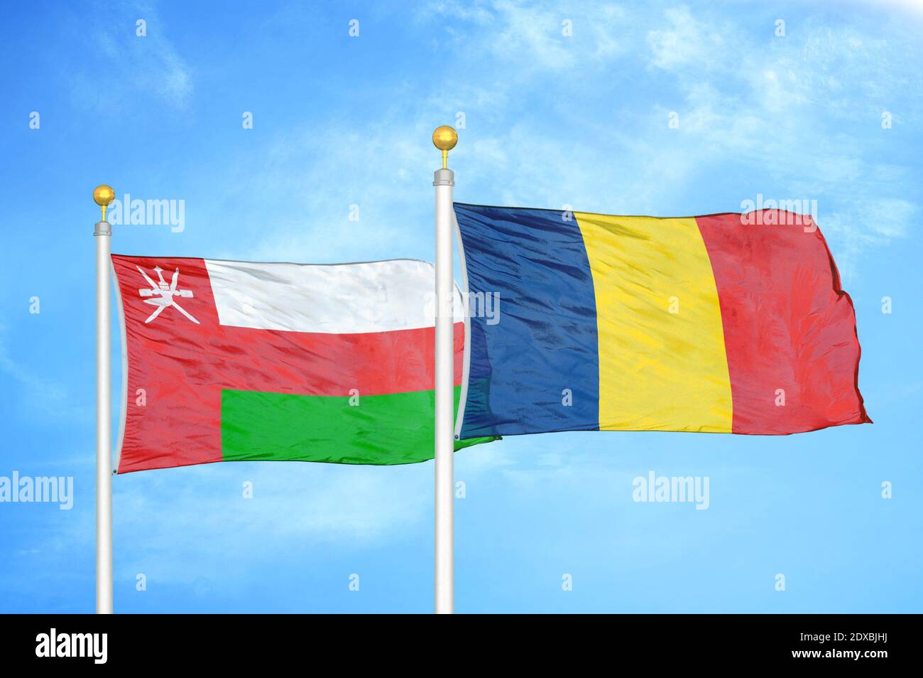 Oman and Chad two flags on flagpoles and blue sky Stock Photo