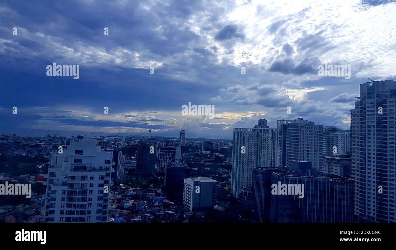 Aerial View Of Buildings In City Against Cloudy Sky Stock Photo