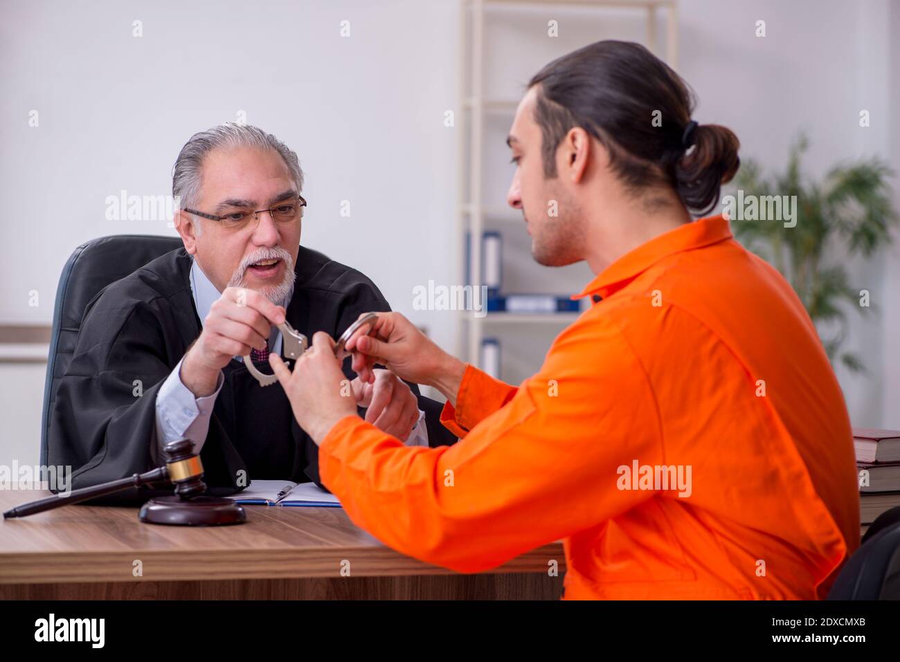 Old judge meeting with young captive in courthouse Stock Photo Alamy