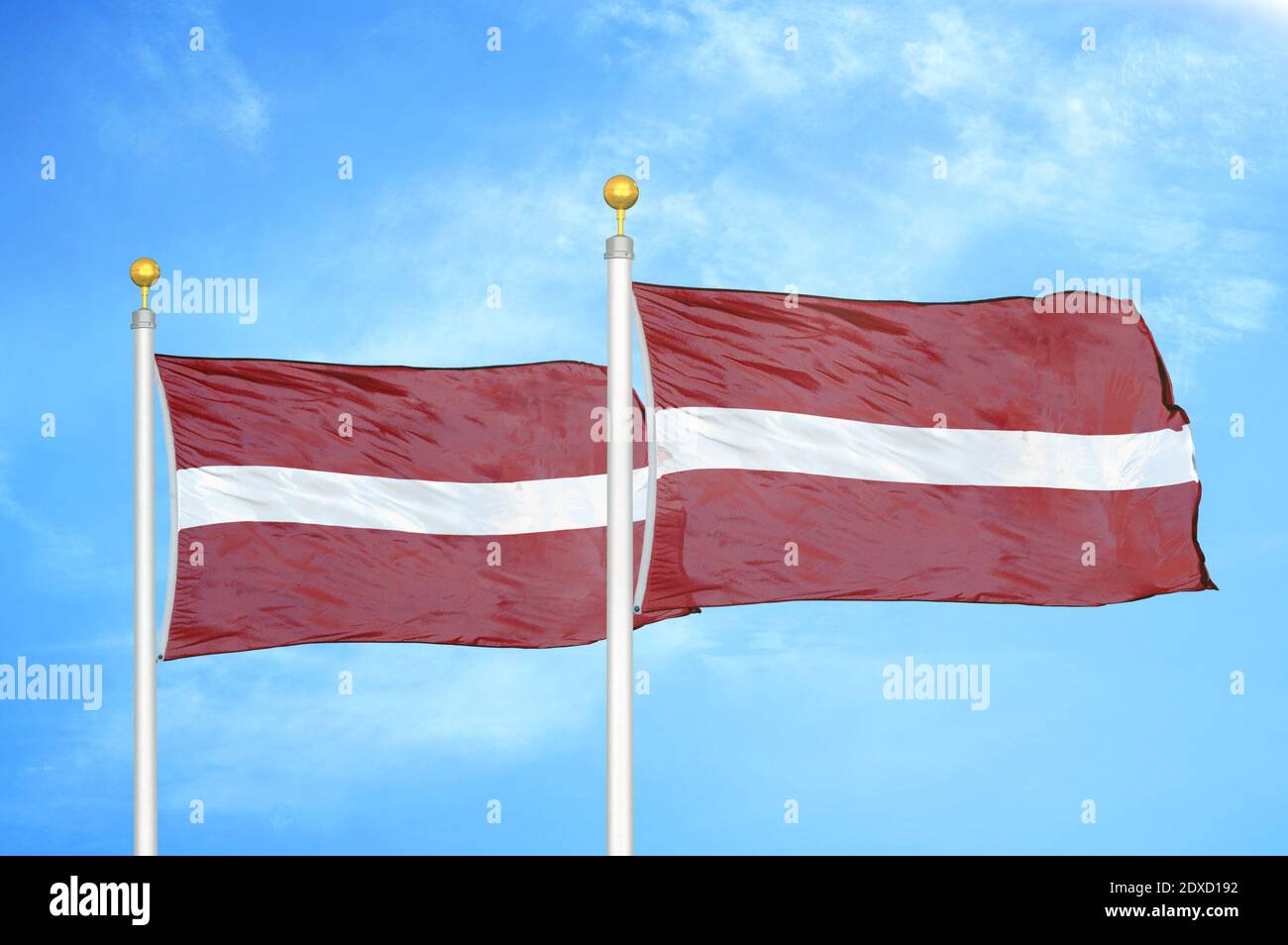 Latvia and Latvia two flags on flagpoles and blue sky Stock Photo