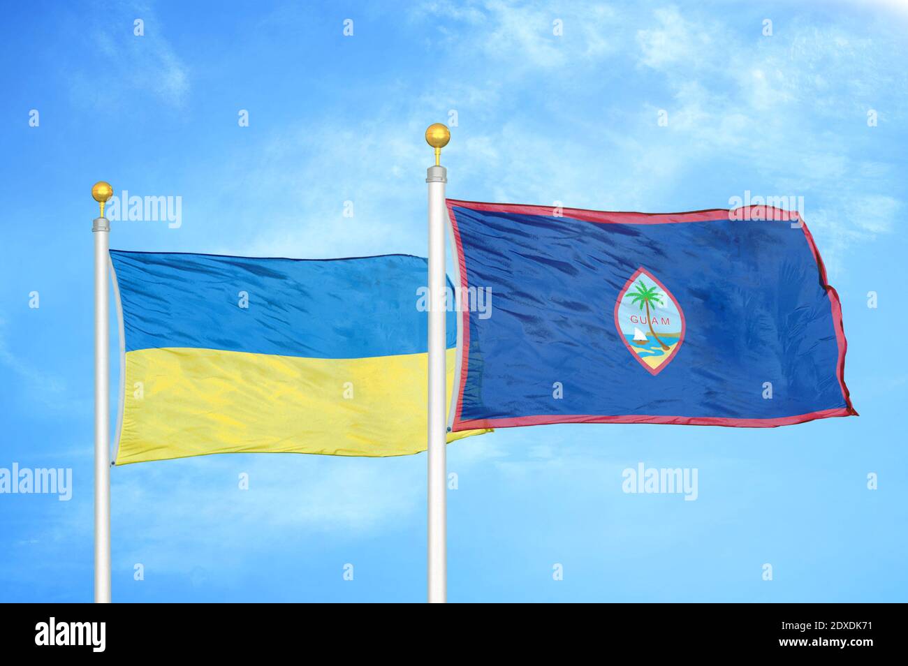 Ukraine and Guam two flags on flagpoles and blue sky Stock Photo