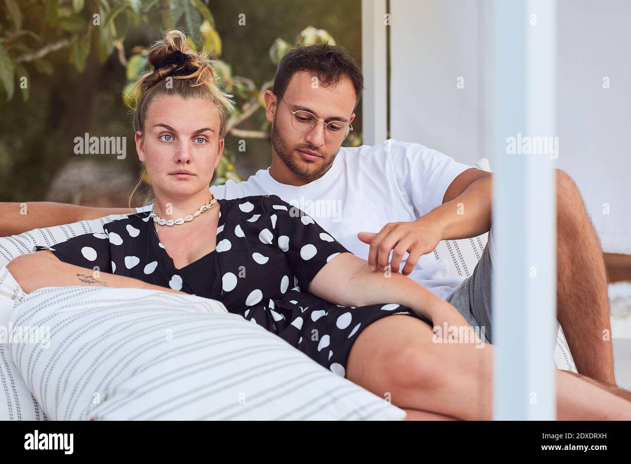 Affectionate young couple relaxing on sofa in back yard Stock Photo