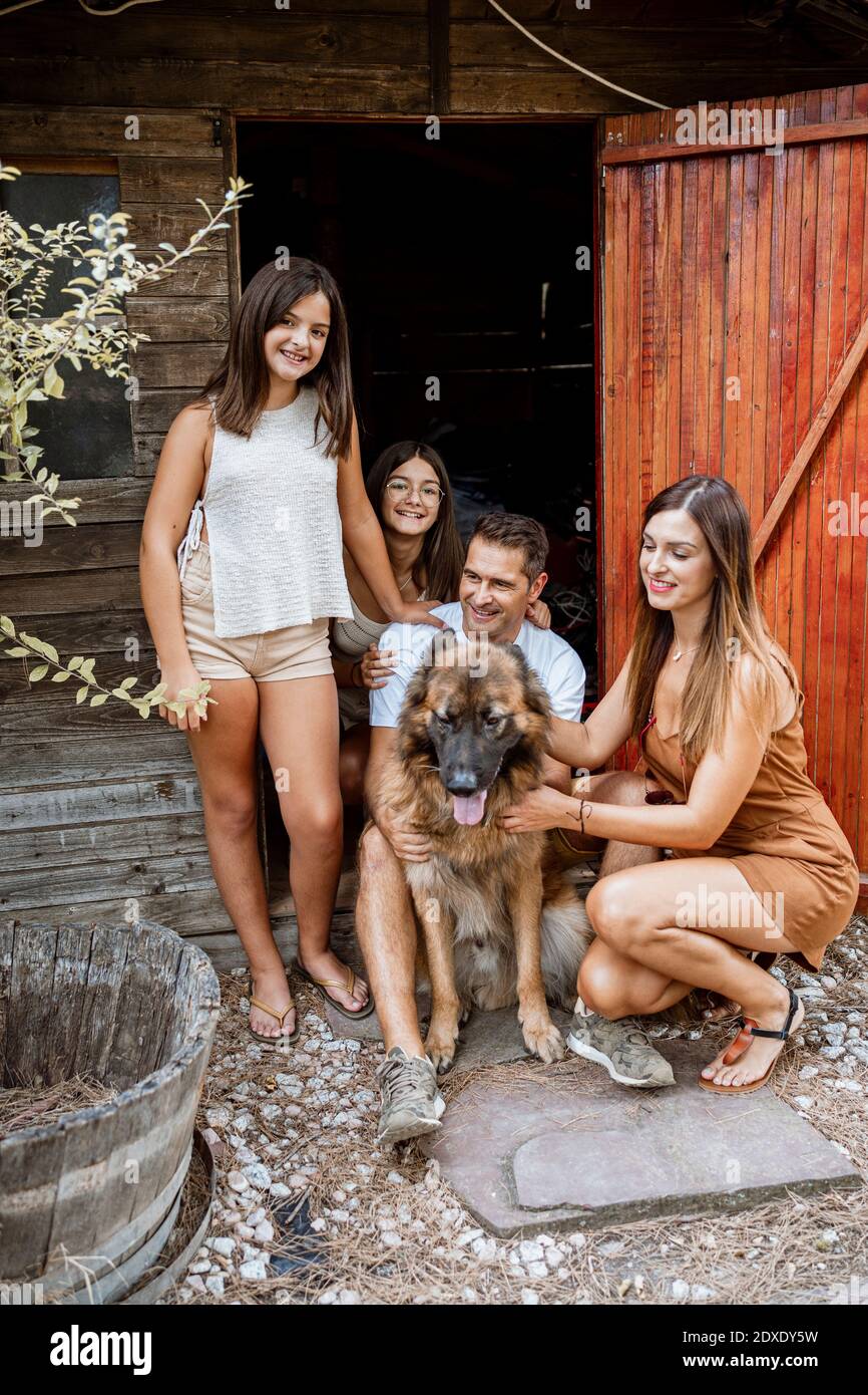 Family with pet dog against doorway in back yard during vacation Stock Photo