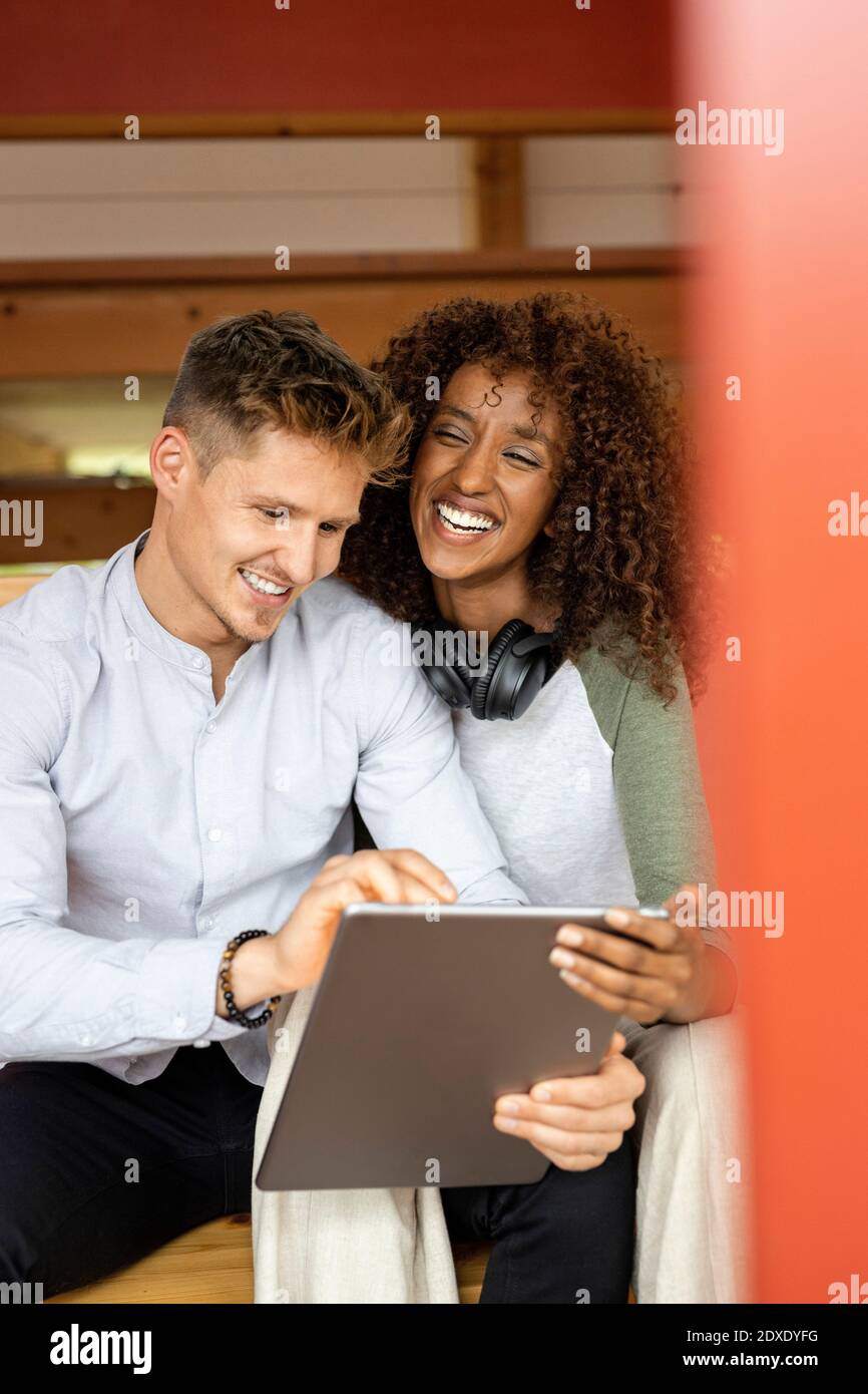 Smiling couple using digital tablet while sitting at home Stock Photo