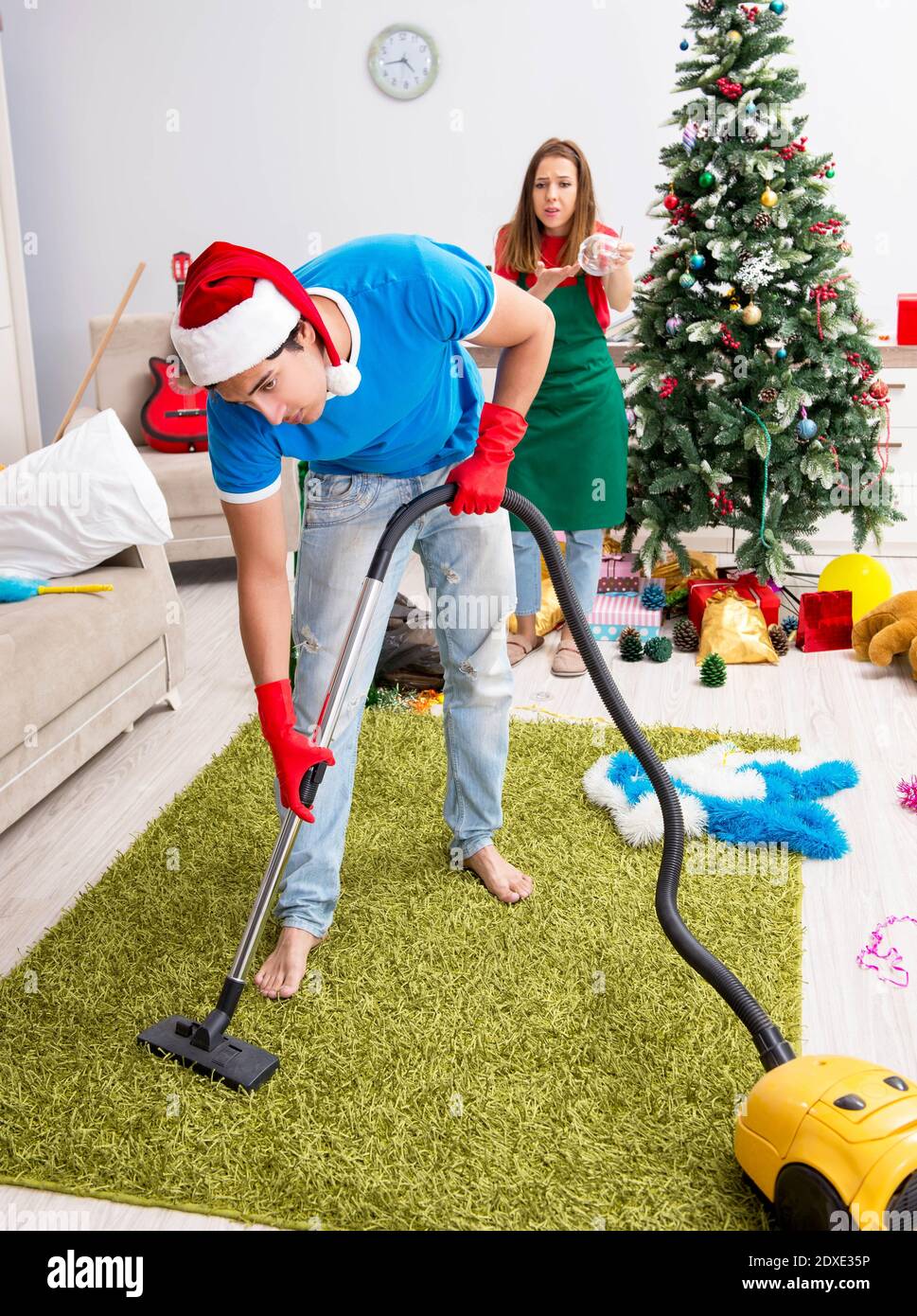 The young family cleaning apartment after christmas party Stock Photo ...