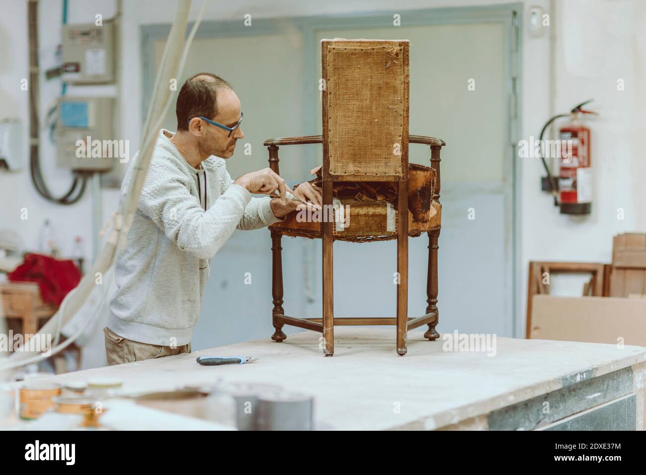 Expertise restoring wood chair while standing at workshop Stock Photo