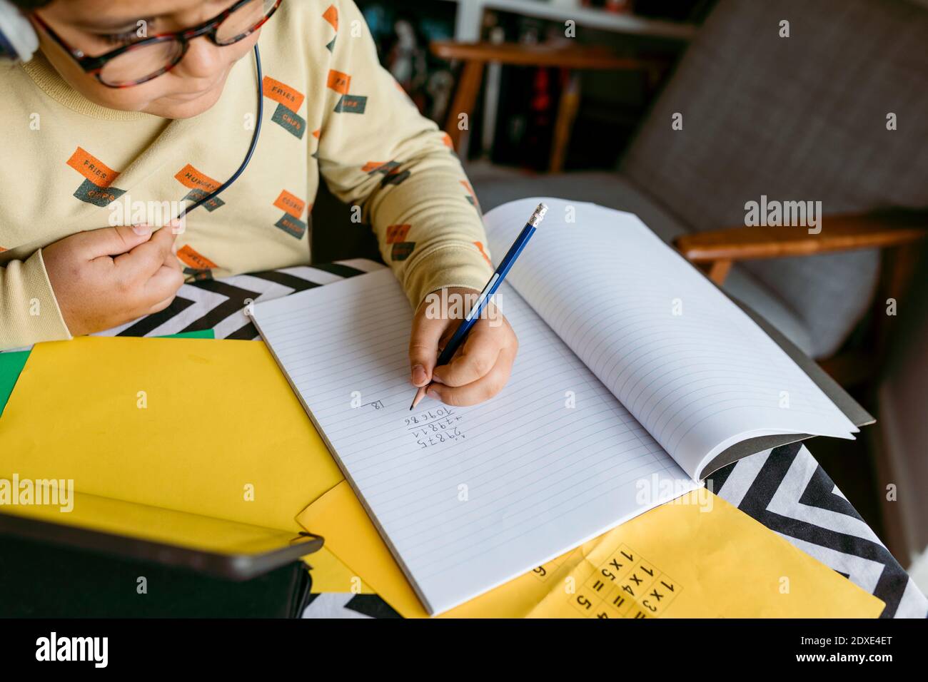 Elementary boy solving maths problem at table Stock Photo