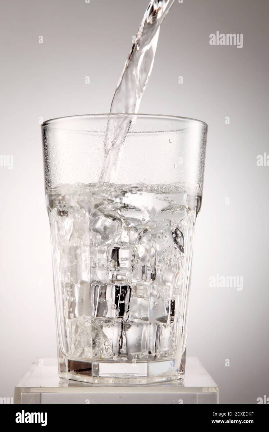 Closeup Of Water Poured In Drinking Glass Against White Background