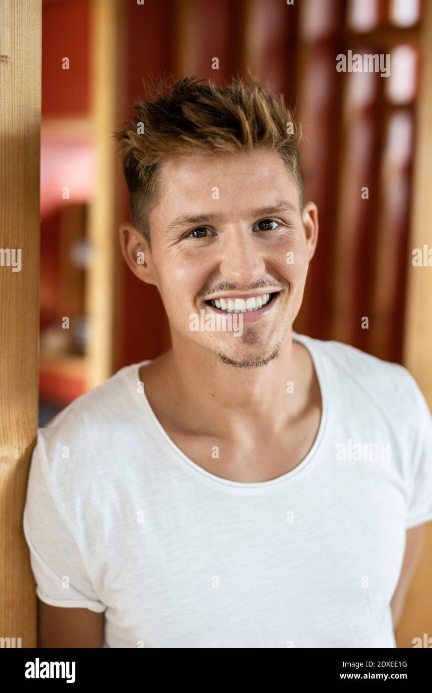 Young man smiling while standing at home Stock Photo