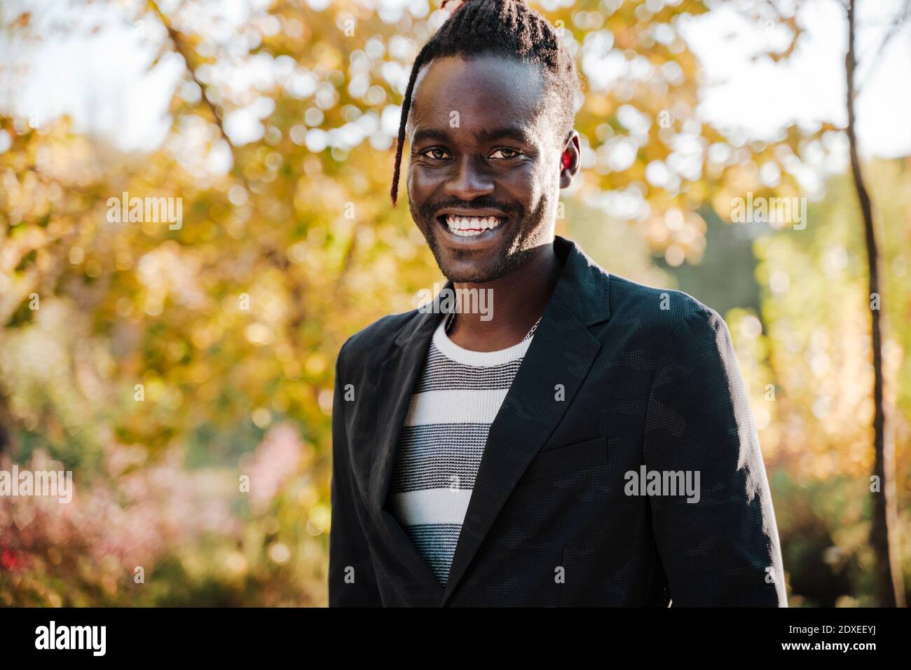 Smiling young African man in park Stock Photo
