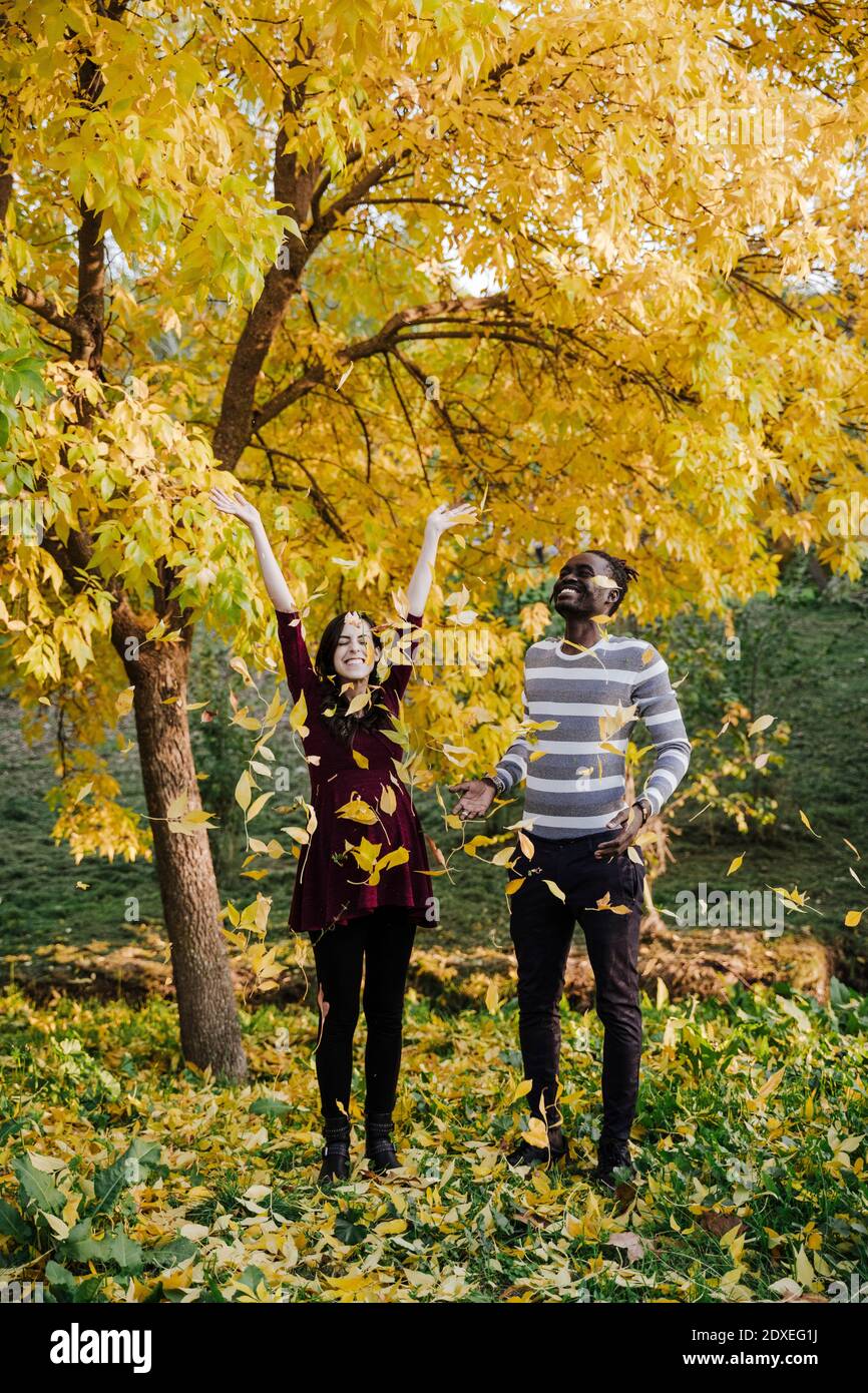 Happy multi ethnic couple playing in park during autumn Stock Photo