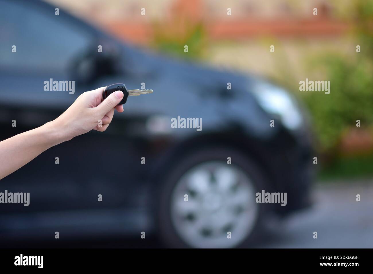 Salesman holding Key of car and car parked background Stock Photo - Alamy