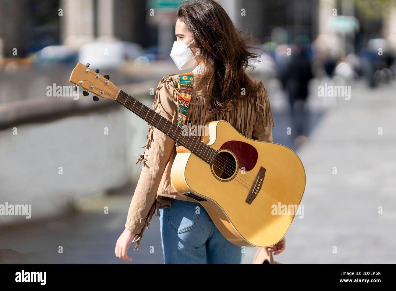 Female musician with guitar during pandemic Stock Photo