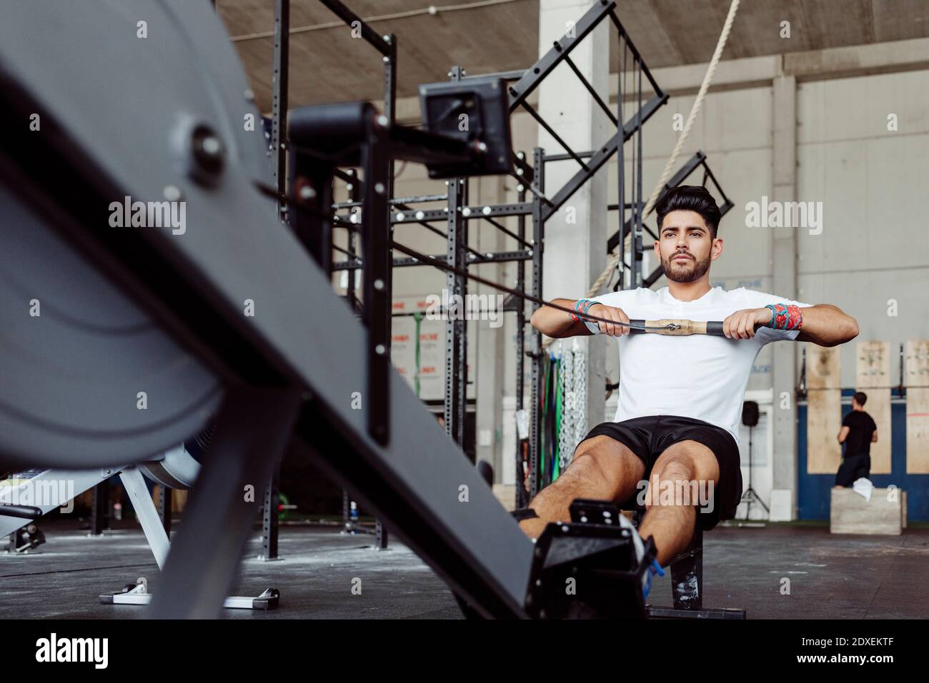 Sportsman exercising with rowing machine at gym Stock Photo