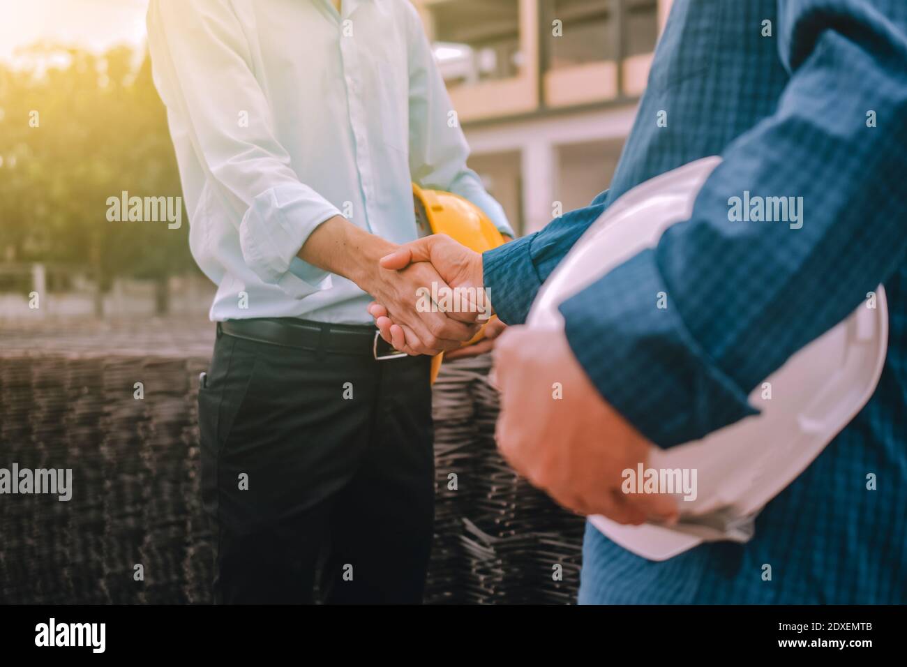 Closeup hand Engineer shake hands agree success project at construction work place Stock Photo