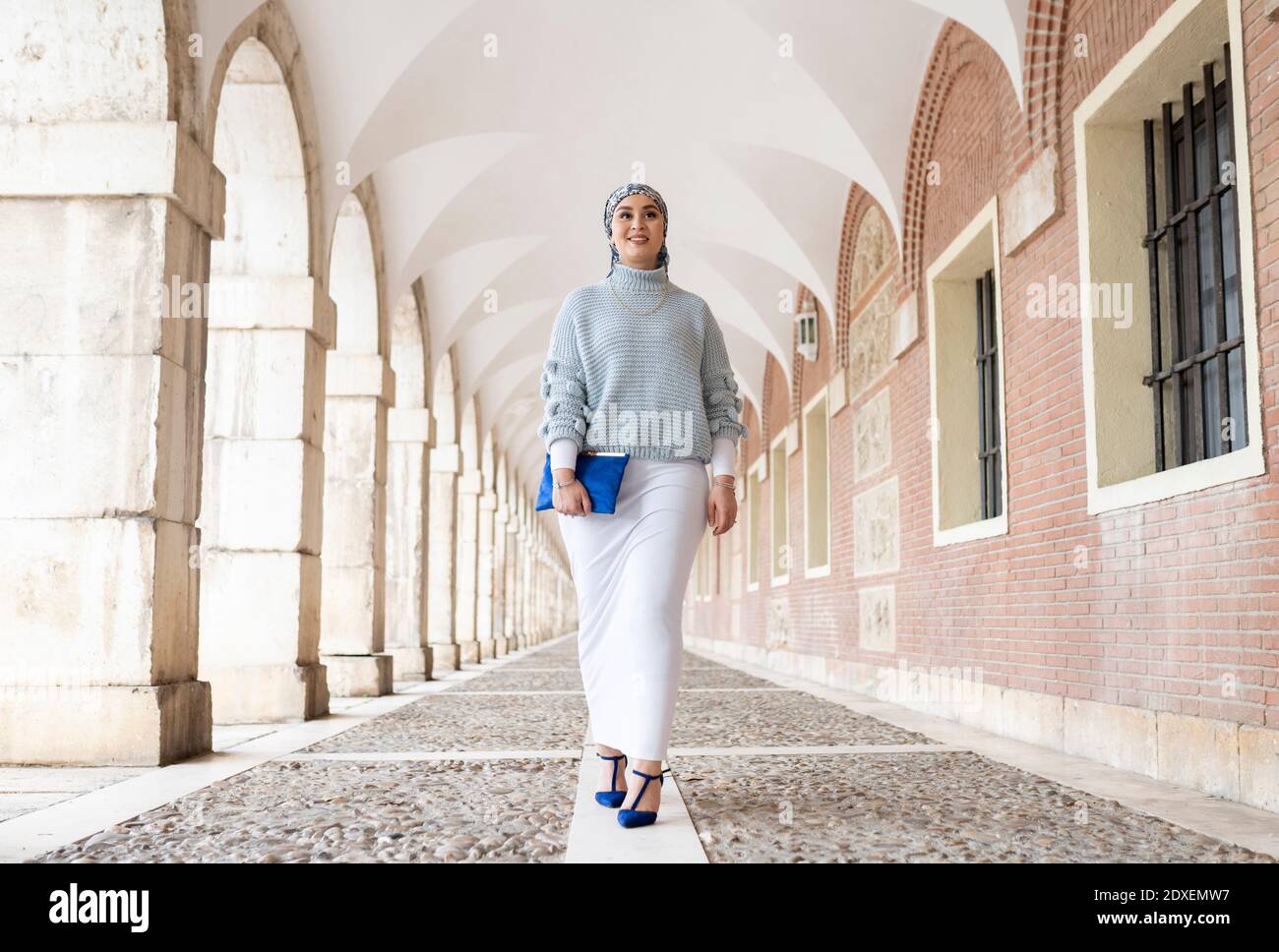 Young woman wearing headscarf walking at corridor Stock Photo
