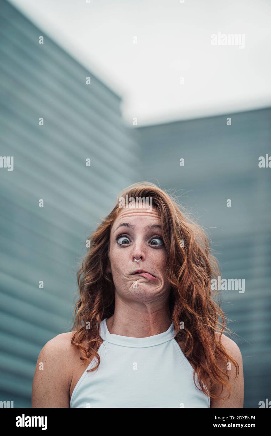 Woman showing weird facial expression while standing outdoors Stock Photo