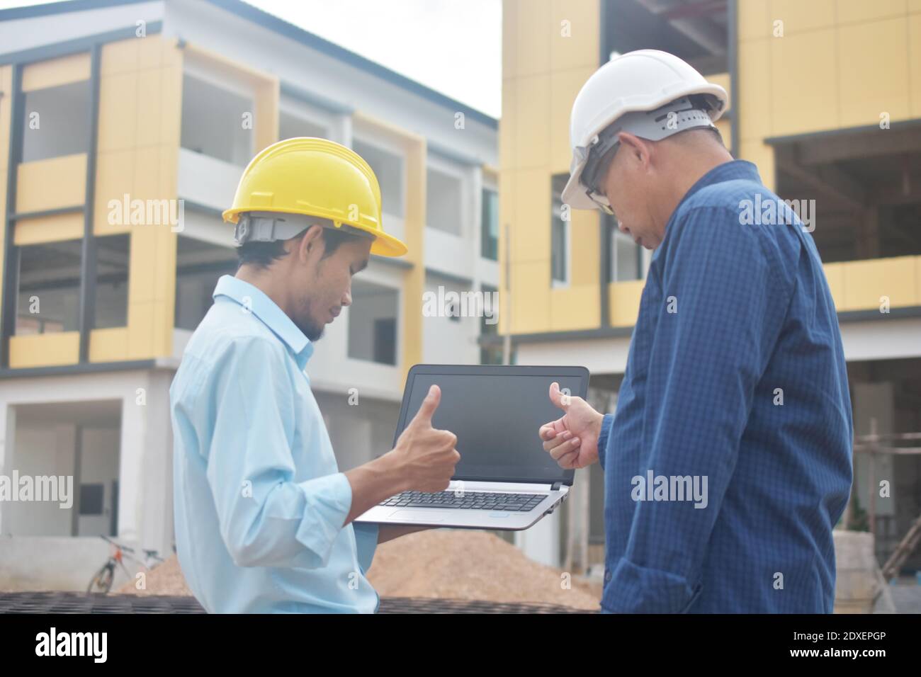 Two Engineering use computer notebook presentation at work place building estate construction background Stock Photo