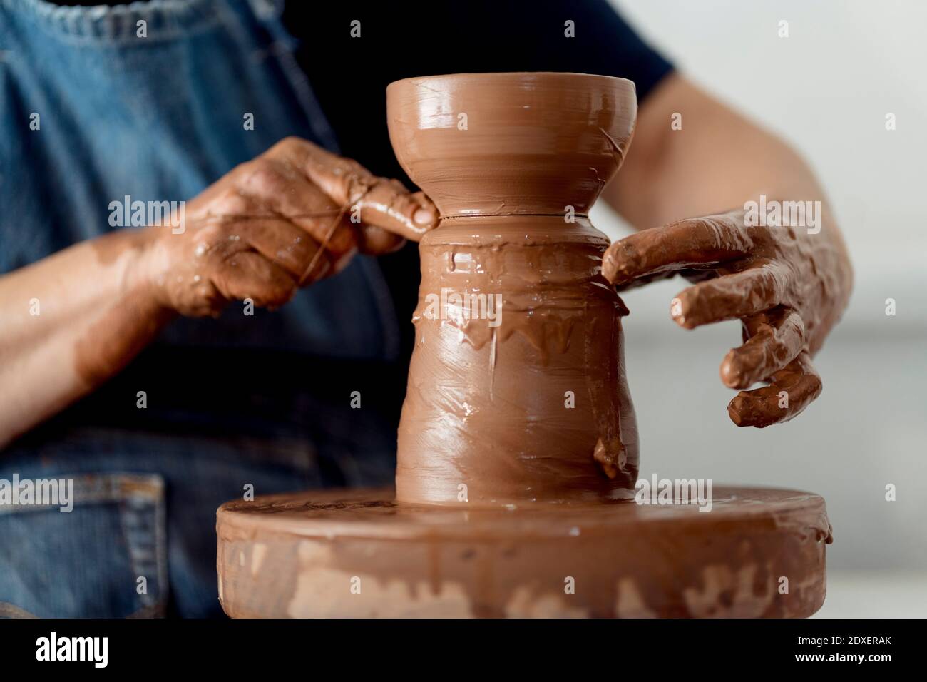 Mature female artist making pottery from clay at workshop Stock Photo ...