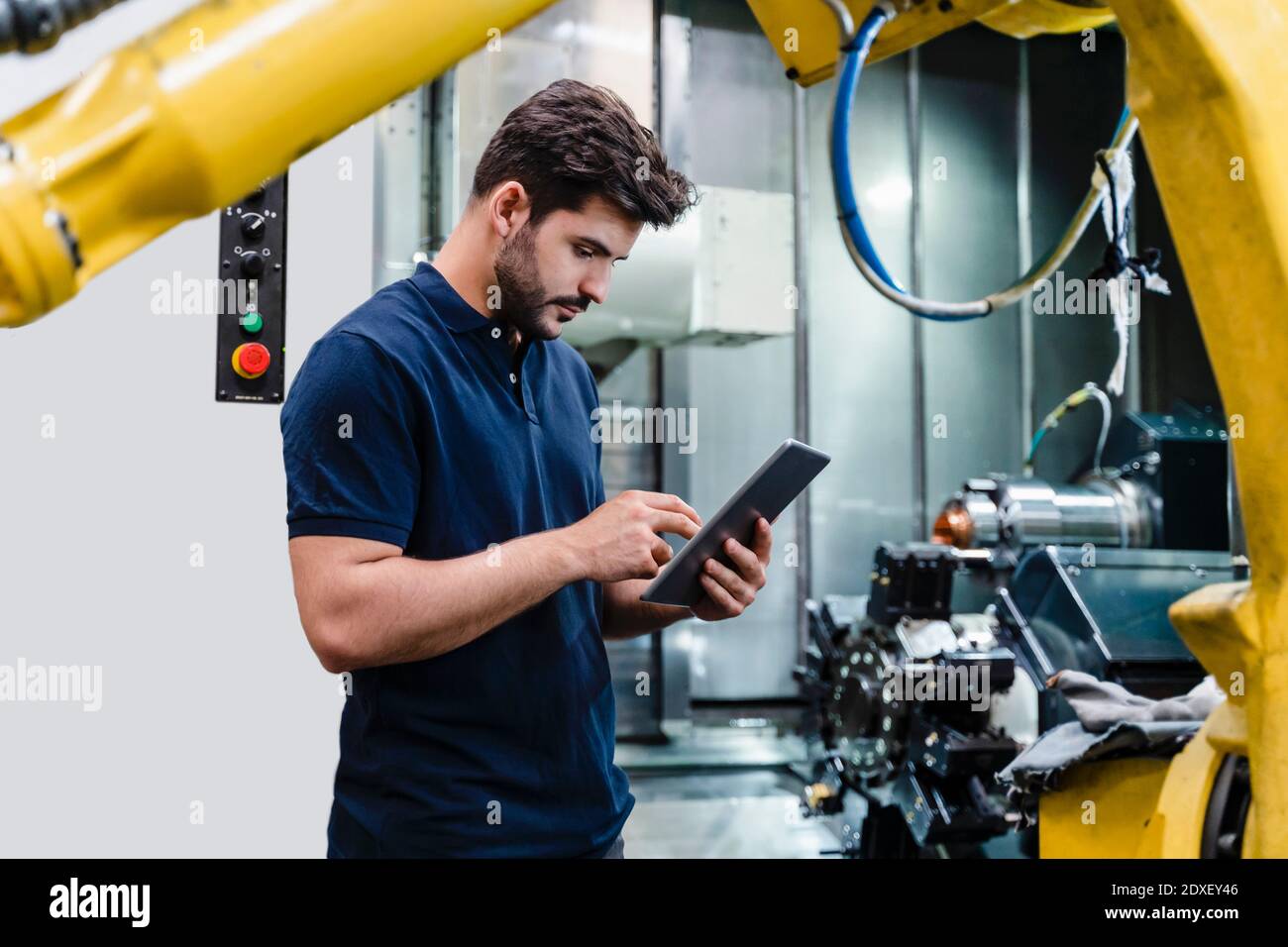 Male worker using digital tablet while standing in factory Stock Photo