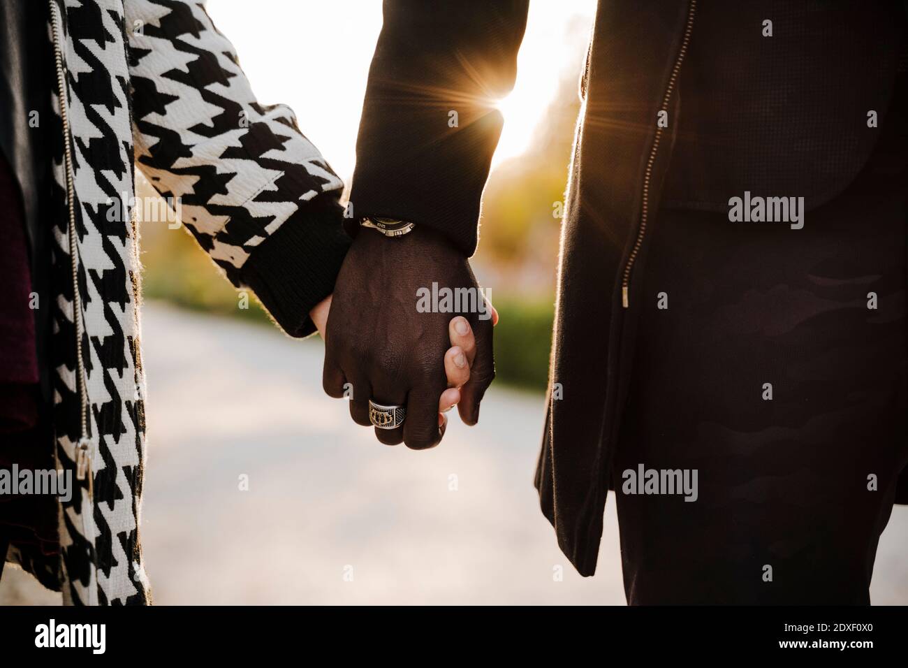 Multi ethnic couple holding hands in park during autumn Stock Photo
