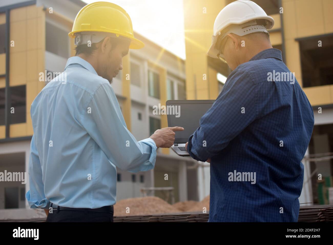 Two Engineering use computer notebook presentation at work place building estate construction background Stock Photo