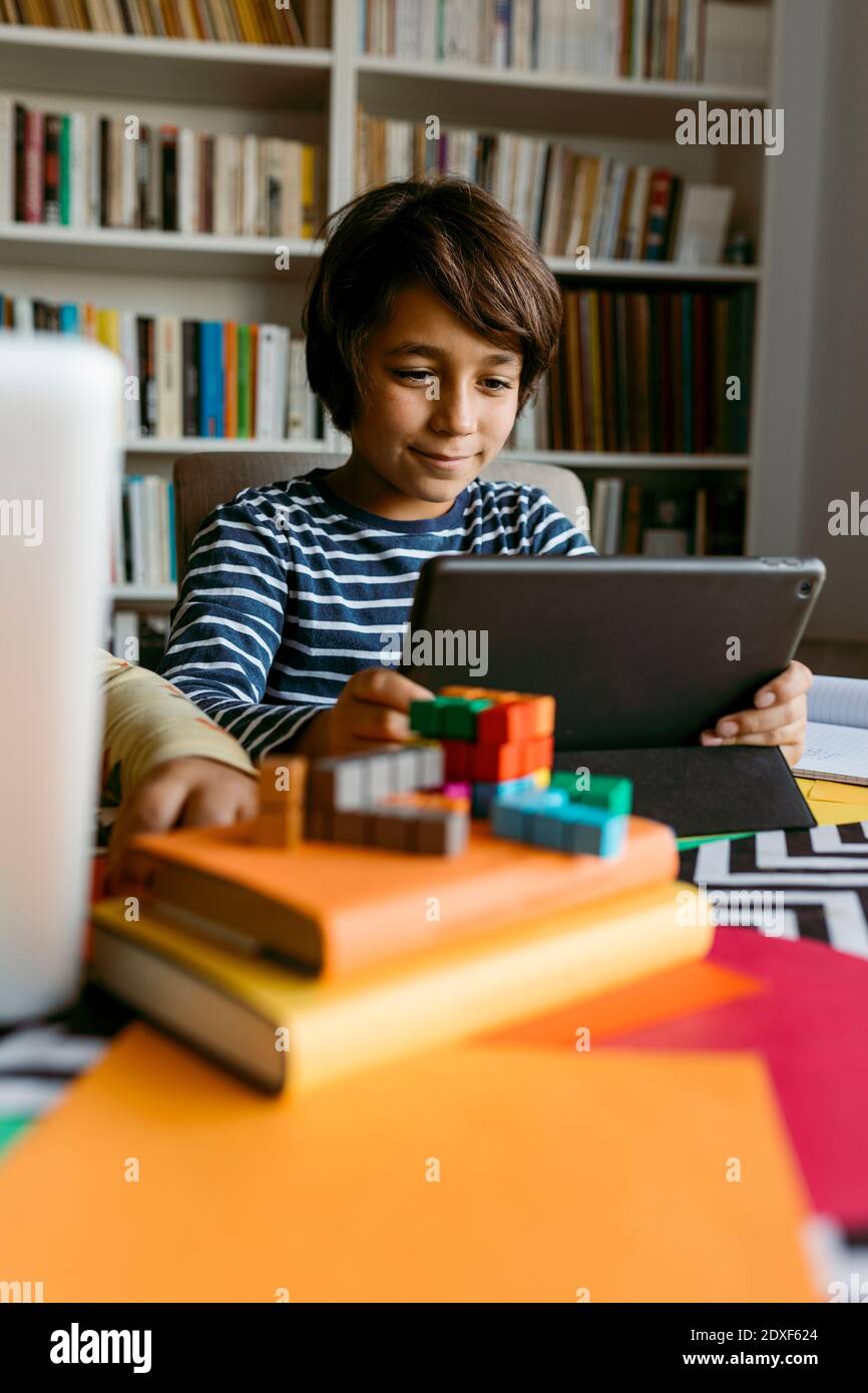 Smiling boy using digital tablet at table Stock Photo