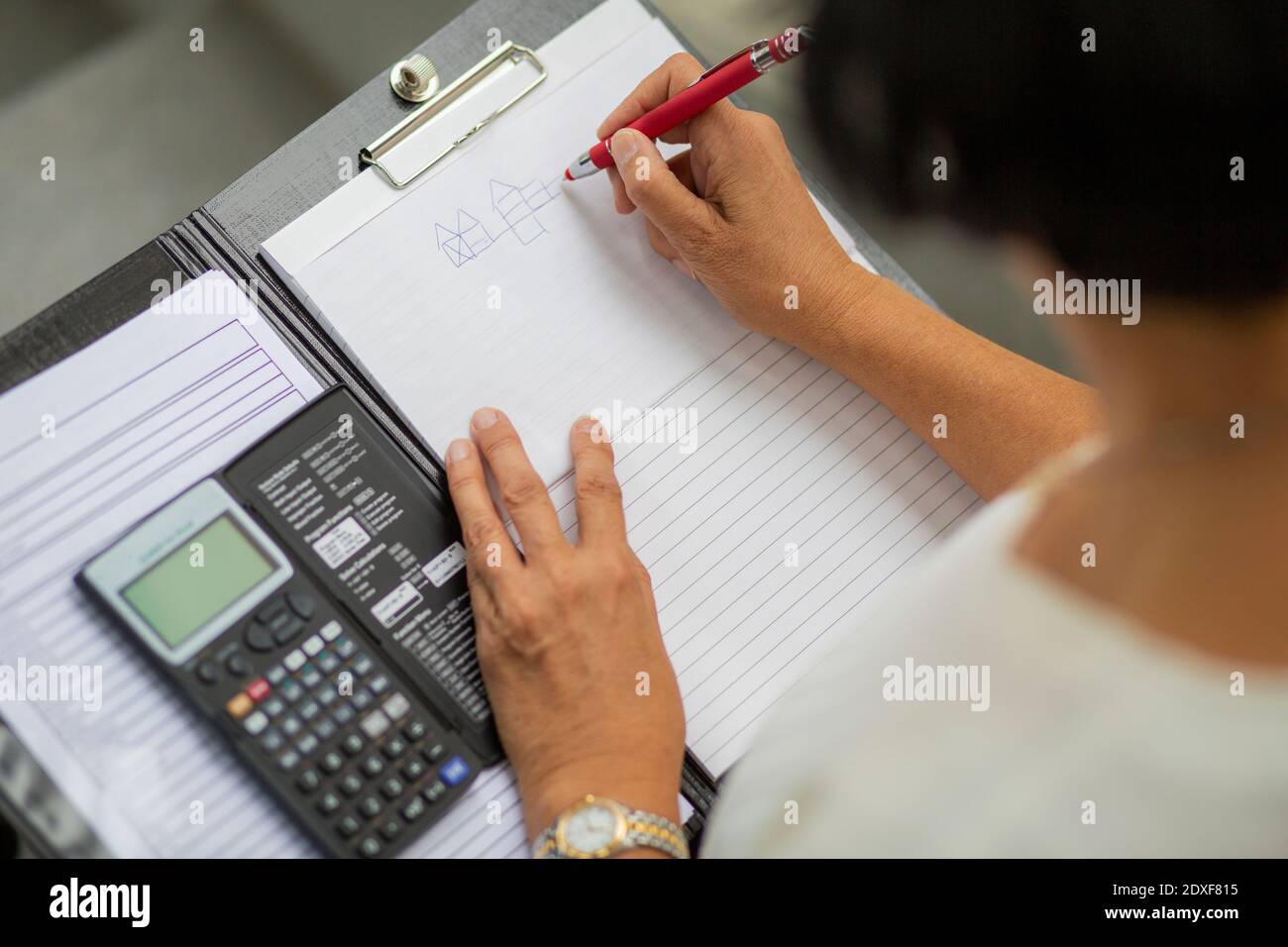 Female architect drawing diagram on clipboard Stock Photo