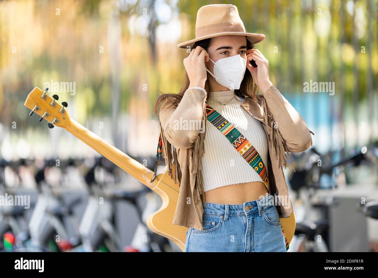 Young woman against wearing protective face mask during pandemic Stock Photo