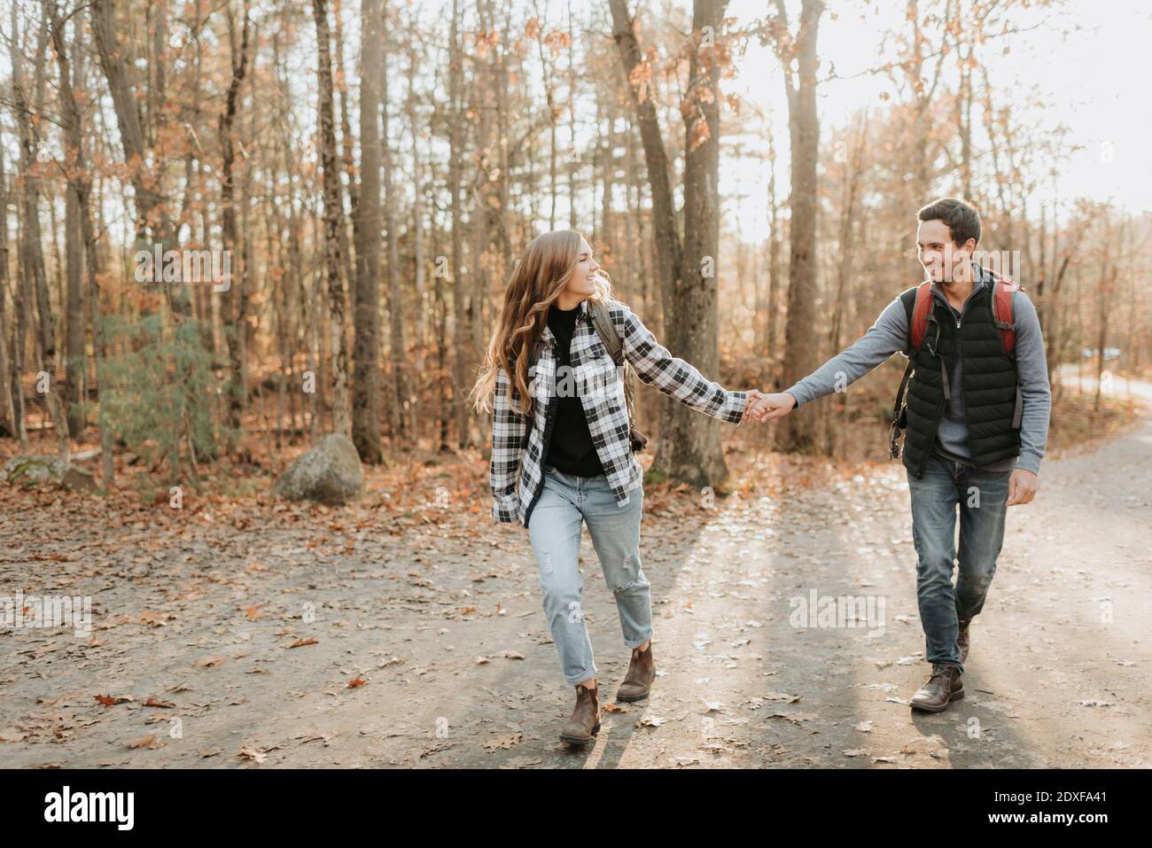 Young couple holding hands during autumn hike Stock Photo - Alamy