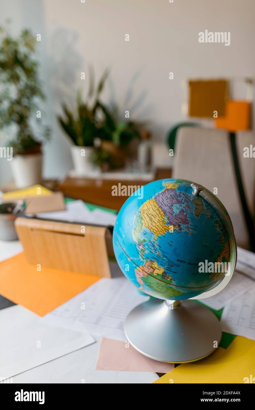 World globe with papers on table Stock Photo